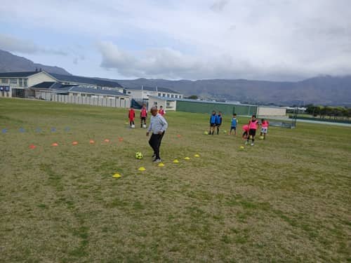 FS4 coach demonstrating a cone dribbling drill to players